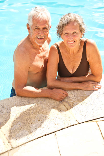 istock High angle view of happy senior couple at poolside 1136417593