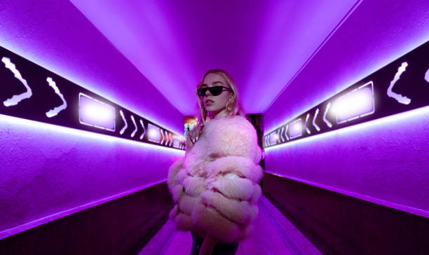 teen hipster girl in stylish glasses and fur standing in purple neon lights elements on street wall, female teenager fashion model woman posing in city night violet bright club glow, back to 80s - letter z imagens e fotografias de stock