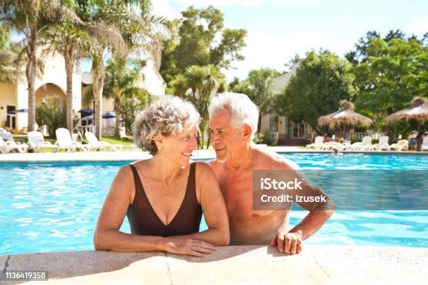 Smiling Senior Couple Looking At Each Other Stock Photo - Download Image Now - Senior Couple, Tourist Resort, Vacations