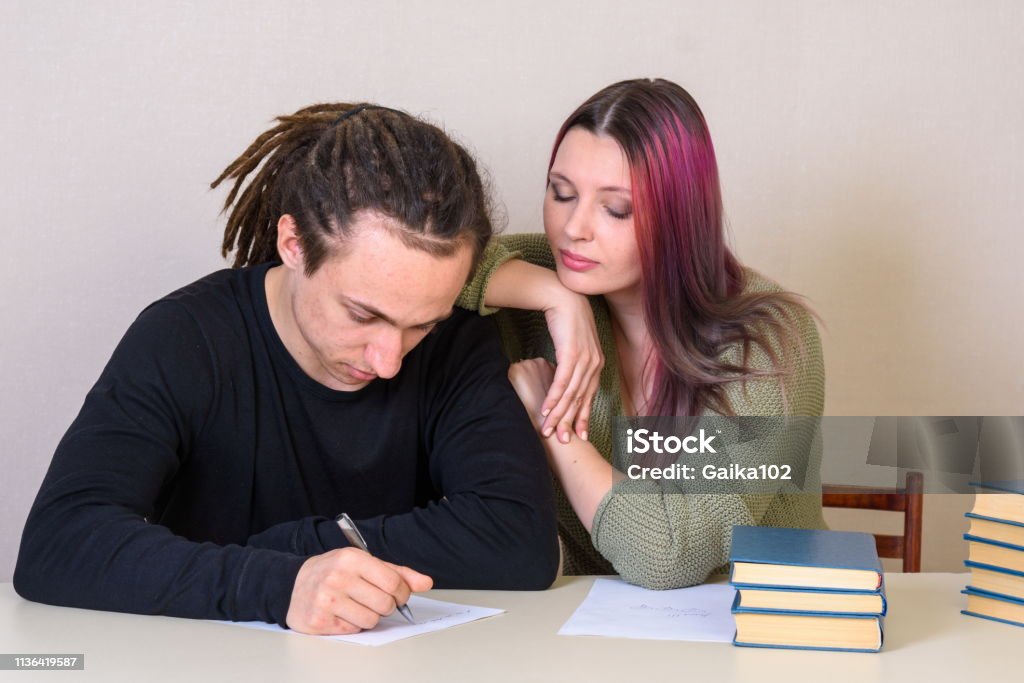 Young girl and teenager look at each other at the table Arguing Stock Photo