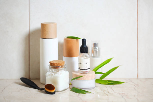 gesichtscreme, serum, lotion, feuchtigkeitscreme und meersalz unter bambusblättern - ware stock-fotos und bilder