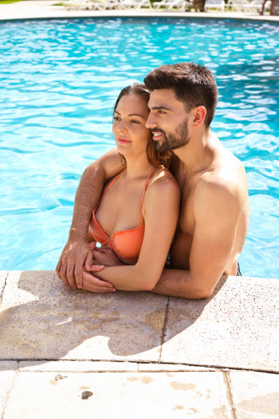 istock Romantic couple embracing in swimming pool 1136425398
