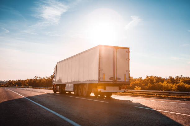 istock semitruck driving to sunset 1136425831
