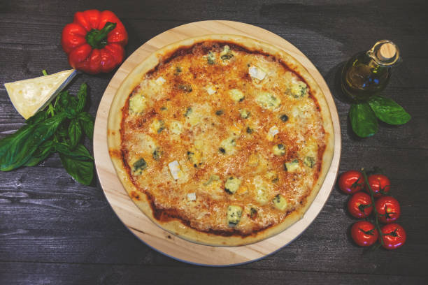 istock appetizing pizza with four cheeses with olive oil and basil leaves on a black table, flat lay, retro toned 1136426013