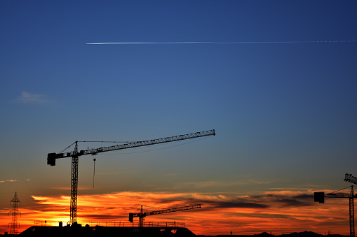 Beautiful urban construction site silhouettes at sunset in a town near to Madrid in Span