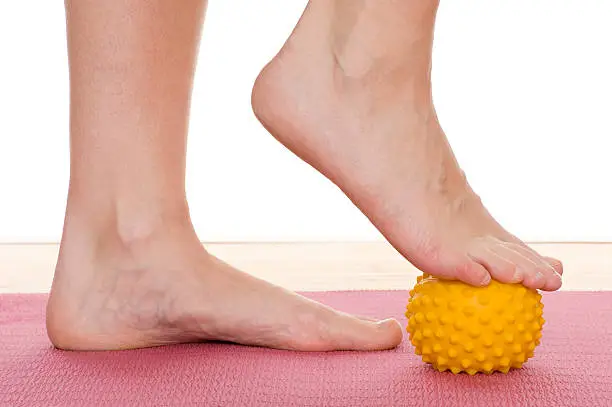 Photo of A pair of feet playing with a spiked rubber ball