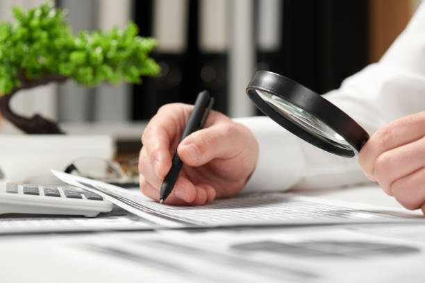istock Businessman working in office and calculating finance. Using magnifying glass. Business financial accounting concept. 1136429310