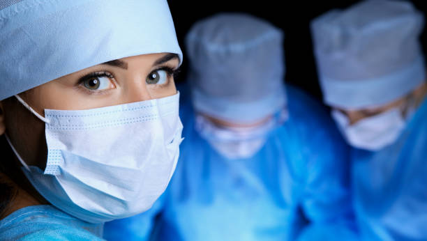 группа хирургов в масках проводит операцию. понятия медицины, хирургии и экстренной помощи - surgical scrub стоковые фото и изображения