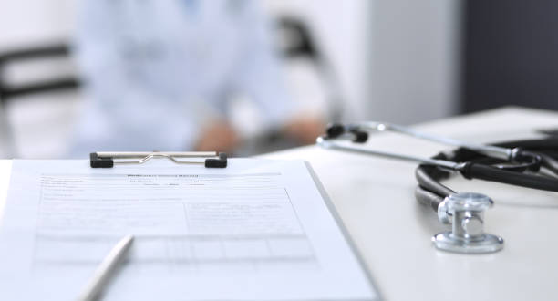 istock Stethoscope, clipboard with medical form lying on hospital reception desk with laptop computer. Medical tools at doctor working table.Medicine and health care concept 1136432988