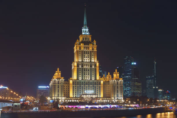 istock Hotel Ukraine (Radisson Royal Hotel) in bright lights and Moskva river with Novoarbatsy bridge in night winter reflections. 1136434109
