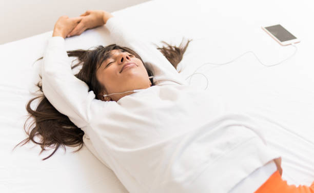 istock Happy Woman sleeping while listening to music 1136435973