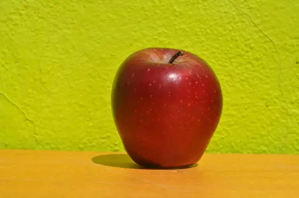 Red apple in a green lime background