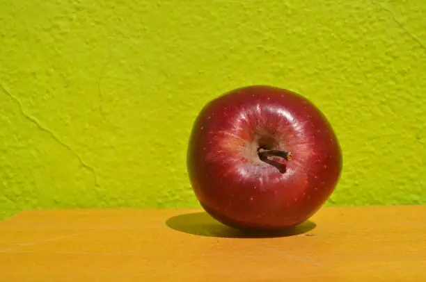Red apple in a green lime background