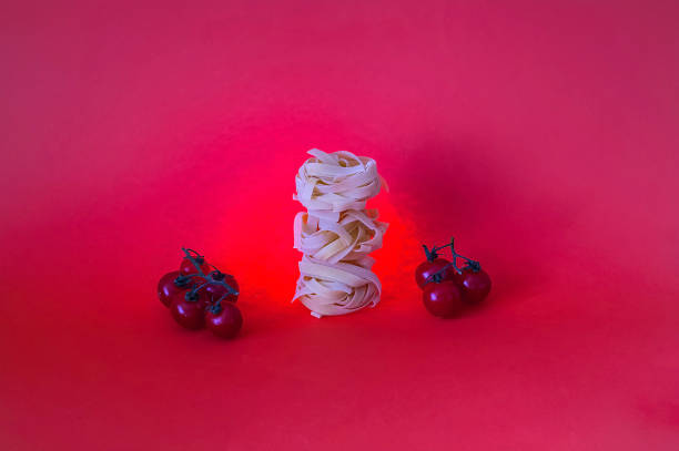 Food background.Italian fettucine pasta on coral background.