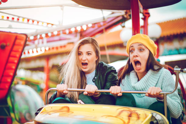 istock Two friends riding amusement park ride 1136444616