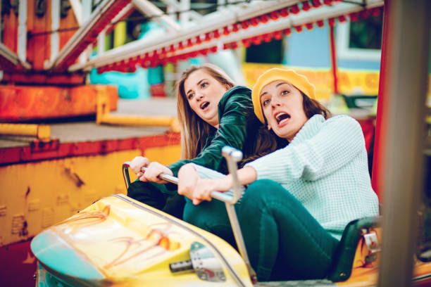 istock Two friends riding amusement park ride 1136444639