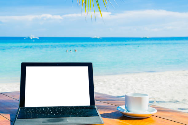 istock Laptop and coffee under palm tree on tropical beach 1136444667