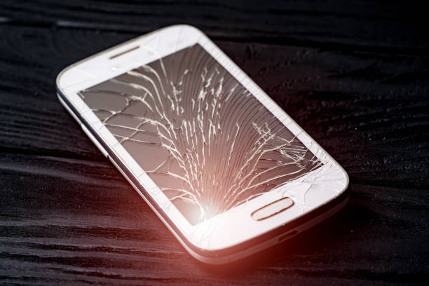 istock Damaged screen of a broken smartphone isolated on dark background. 1136445936