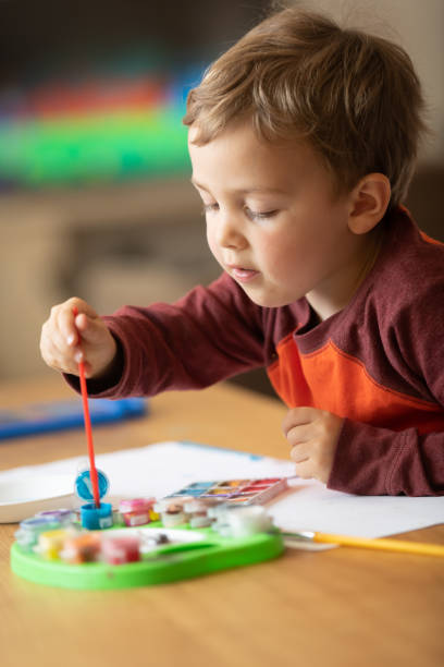 istock Three years old child painting with watercolors 1136449172