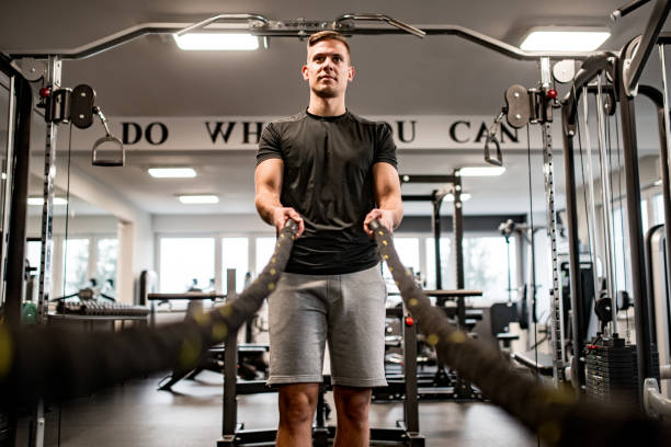 istock Young man holding Battle ropes at Gym 1136449222