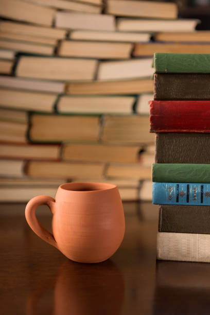 istock clay cup and many books on a wooden table 1136449471