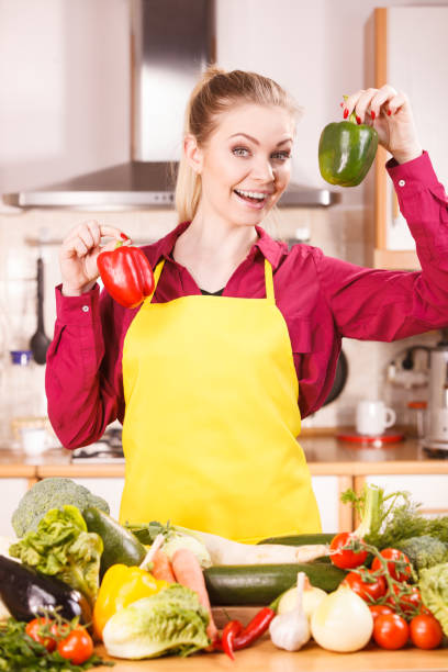 istock Woman holding two bell peppers 1136450331