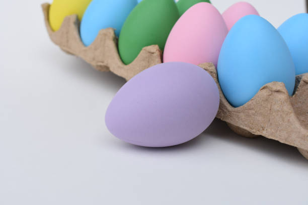 istock Light purple egg with other easter eggs in carton 1136450479