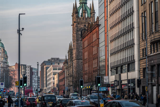 Belfast, United Kingdom - February 27, 2019:  The view northwards along Great Victoria Street (Belfast, Northern Ireland) towards the Assembly Buildings of the Presbyterian Church in Ireland (RHS spire, 1905) and the neo-classical domes of John Bell House, a student accommodation building (LHS, 1906).