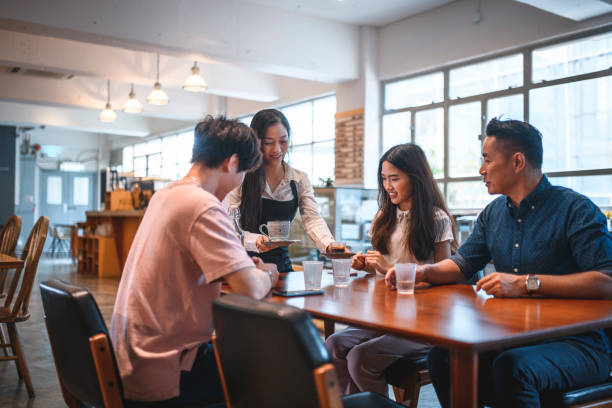 istock Female barista serving coffee to customers 1136457061