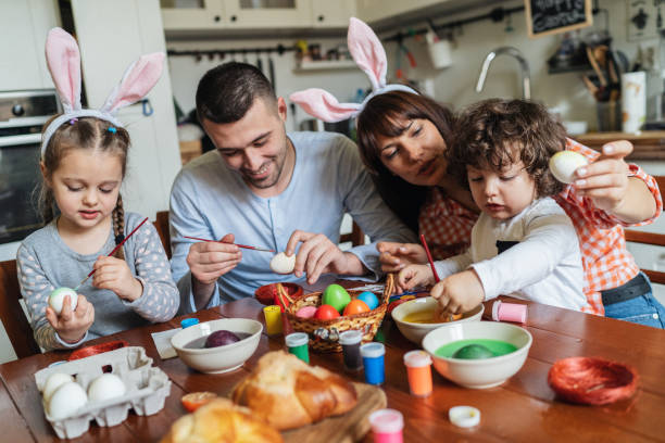 istock Happy family painting Easter eggs 1136458294