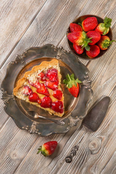 Delicious berry cake with fresh strawberries on an old antique silver platter. Fresh strawberries, dessert, photo in retro style. Vintage, top view. Delicious berry cake with fresh strawberries on an old antique silver platter. Fresh strawberries, dessert, photo in retro style. Vintage, top view. silver platter stock pictures, royalty-free photos & images