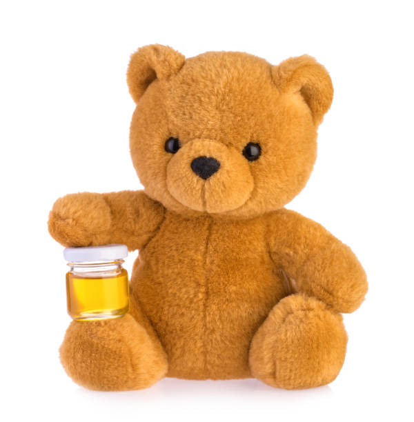 istock Teddy bear holding honey pot isolated white background 1136470136