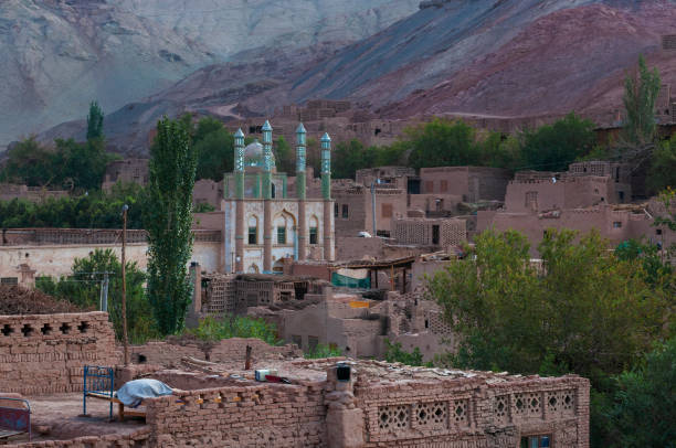 vista da vila de uyghur de tuyog, com uma mesquita e as montanhas no fundo, região de xinjiang - cultura uigur - fotografias e filmes do acervo