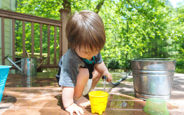 istock Young toddler boy playing with water 1136476981