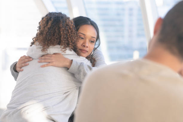 embracing in group therapy - drug awareness imagens e fotografias de stock