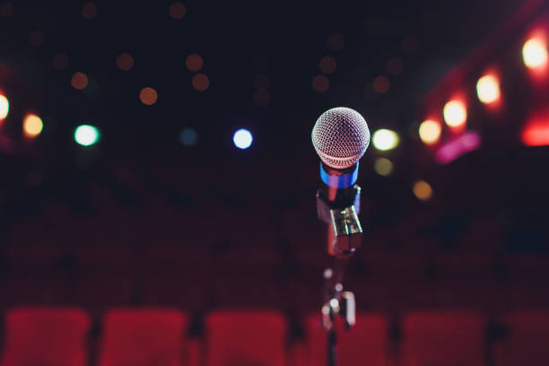 istock microphone on a background of red hall with seating for spectators. 1136477803