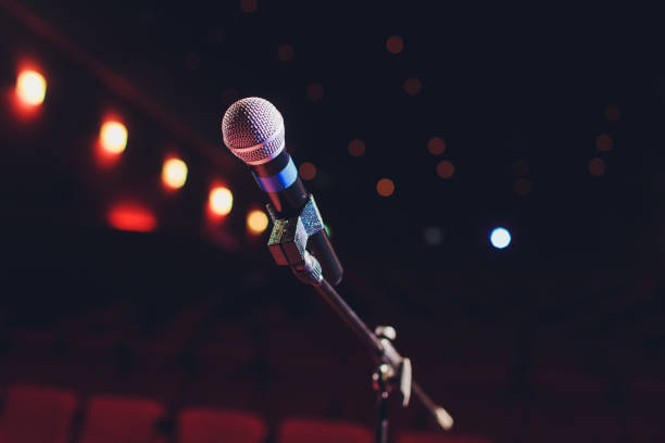 istock microphone on a background of red hall with seating for spectators. 1136477807