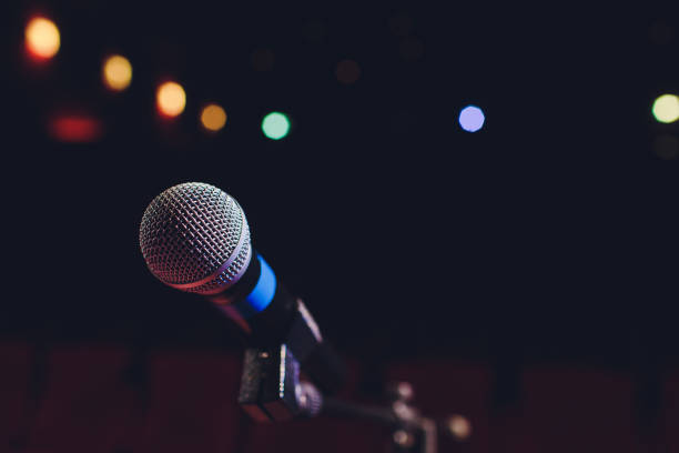 istock microphone on a background of red hall with seating for spectators. 1136477808
