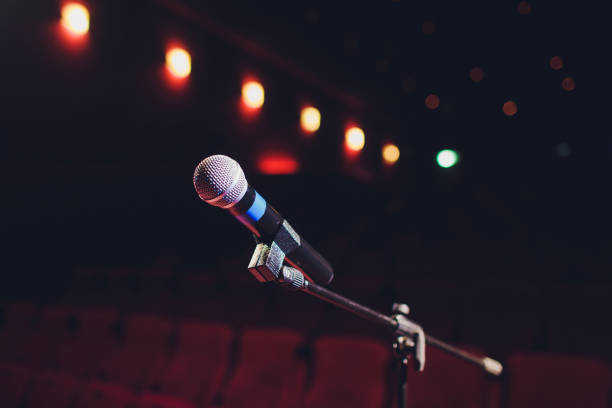istock microphone on a background of red hall with seating for spectators. 1136477809
