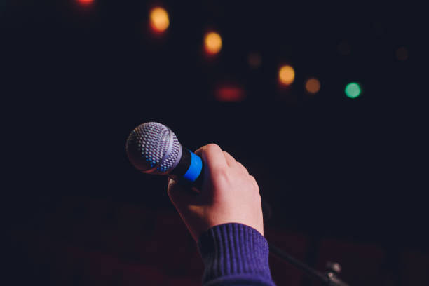 istock microphone on a background of red hall with seating for spectators. 1136477819