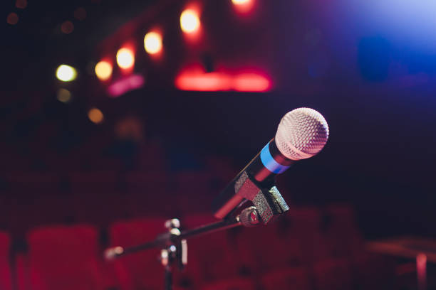 istock microphone on a background of red hall with seating for spectators. 1136477820