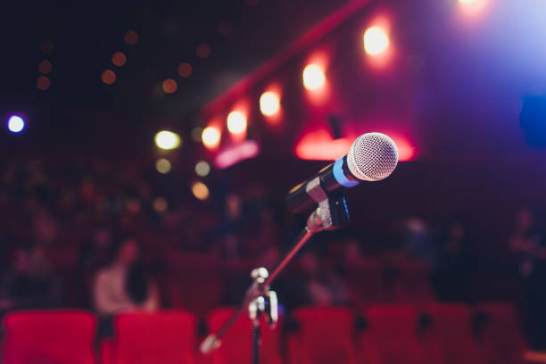 istock microphone on a background of red hall with seating for spectators. 1136477821