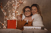 Sisters hugging near the Christmas tree