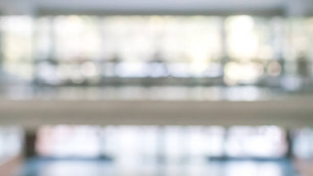 istock Business office corridor blur background interior view empty lobby hallway with glass wall white room and light bokeh 1136478990