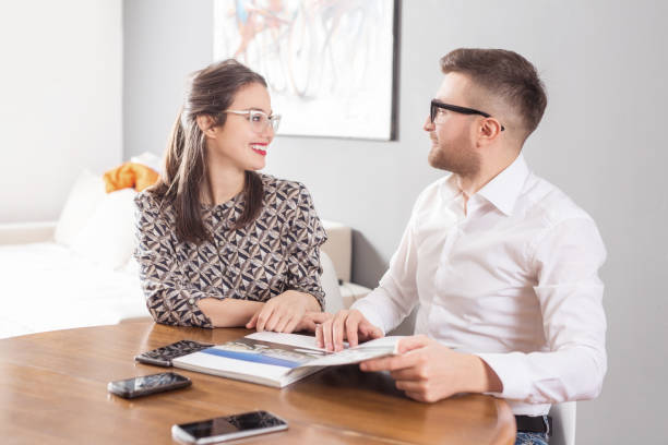 istock Young business married couple sitting at table and reading a book 1136486376