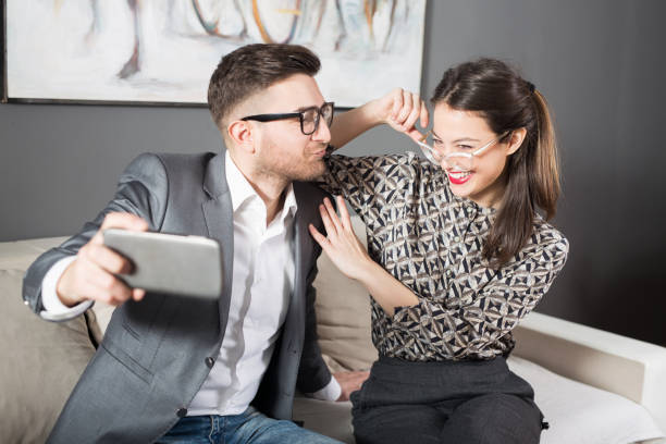 istock Young married couple taking selfies on sofa 1136486380