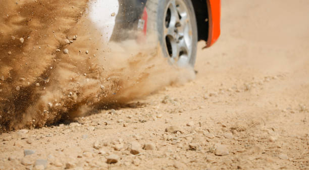 sand spritzt von rallye-rennwagen auf schotterpiste. - rallye weltmeisterschaft stock-fotos und bilder
