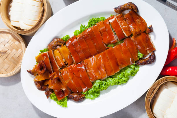 Delicious Golden Roasted BBQ Suckling pig on table. Delicious Golden Roasted BBQ Suckling pig on table. Cantonese Style. suckling stock pictures, royalty-free photos & images