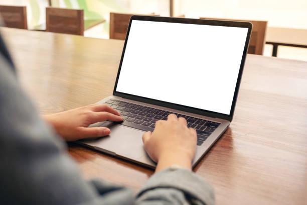 istock a woman using and typing on laptop with blank white desktop screen on wooden table 1136494551