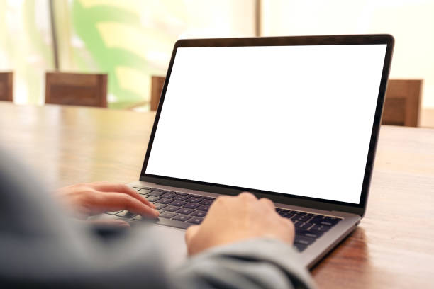 istock a woman using and typing on laptop with blank white desktop screen on wooden table 1136494562